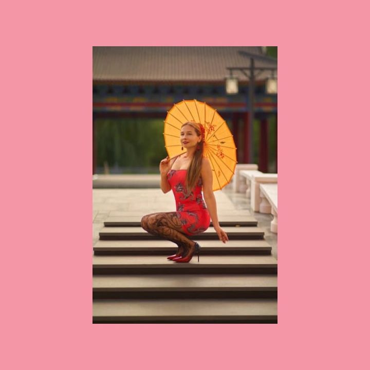 Nuori mies sinisessä puvussa nojaa toimistopöytään modernissa työtilassa, WordPress.