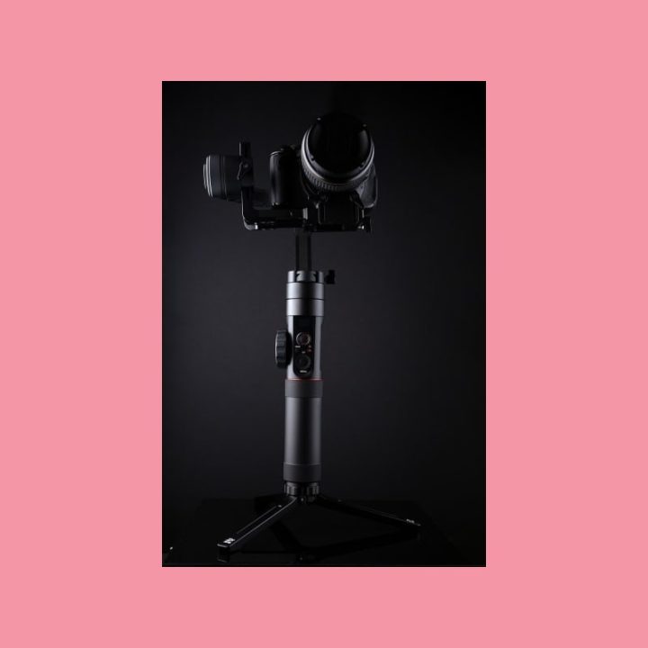 Ammattitason videokamera jalustalla, jossa näyttö, suuntamikrofoni ja matte box, havainnollistaa videotuotannon hintaa.